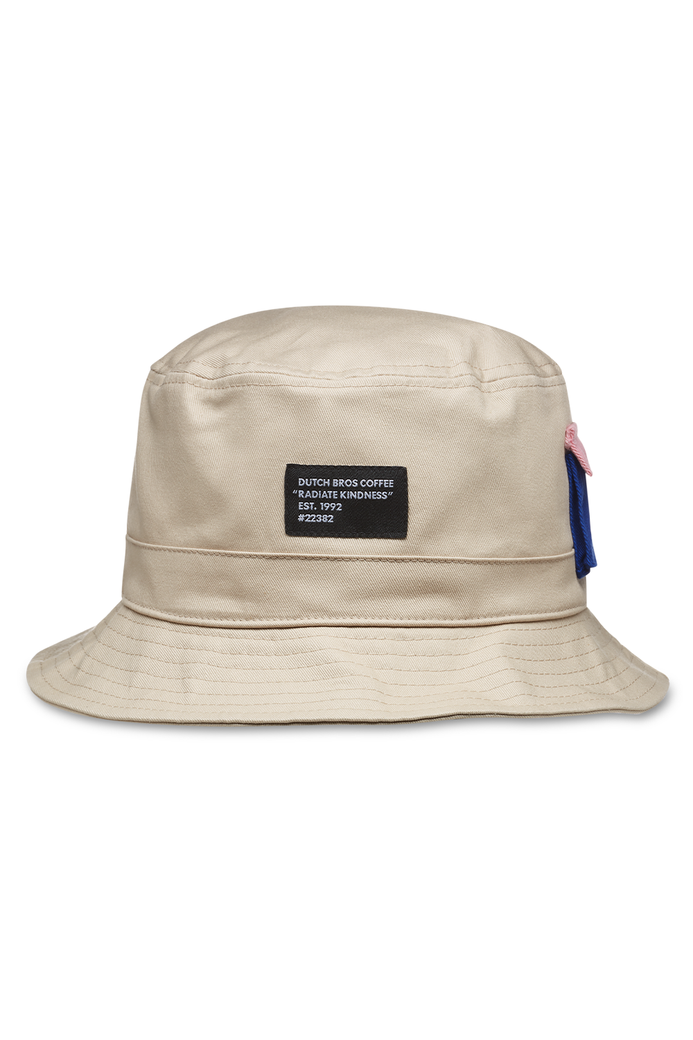 A beige bucket hat with a pocket on the front, displaying a brand tag that says dutch bros coffee, radiate kindness est. 1992, suitable for casual wear.