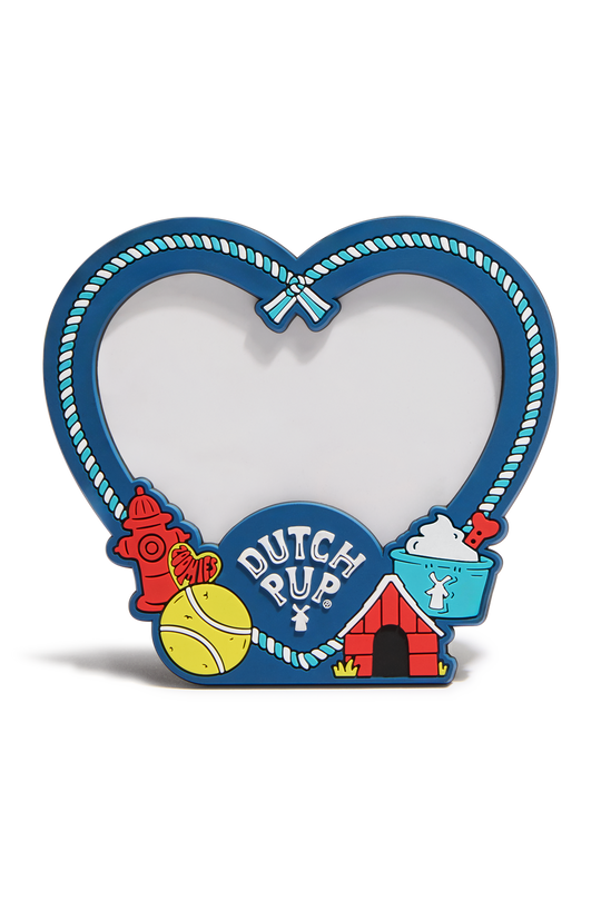 A heart-shaped decorative picture frame with a blue border, rope-style trim, and colorful dog-themed illustrations including a red fire hydrant, yellow tennis ball, red dog house, and blue bucket. The center reads 'DUTCH PUP' in white text.