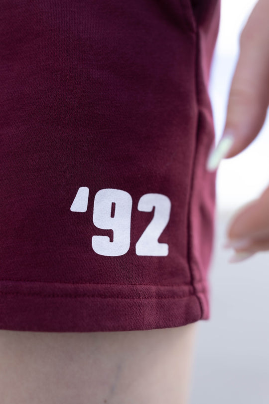 Maroon shorts with '92' printed on a blurred background