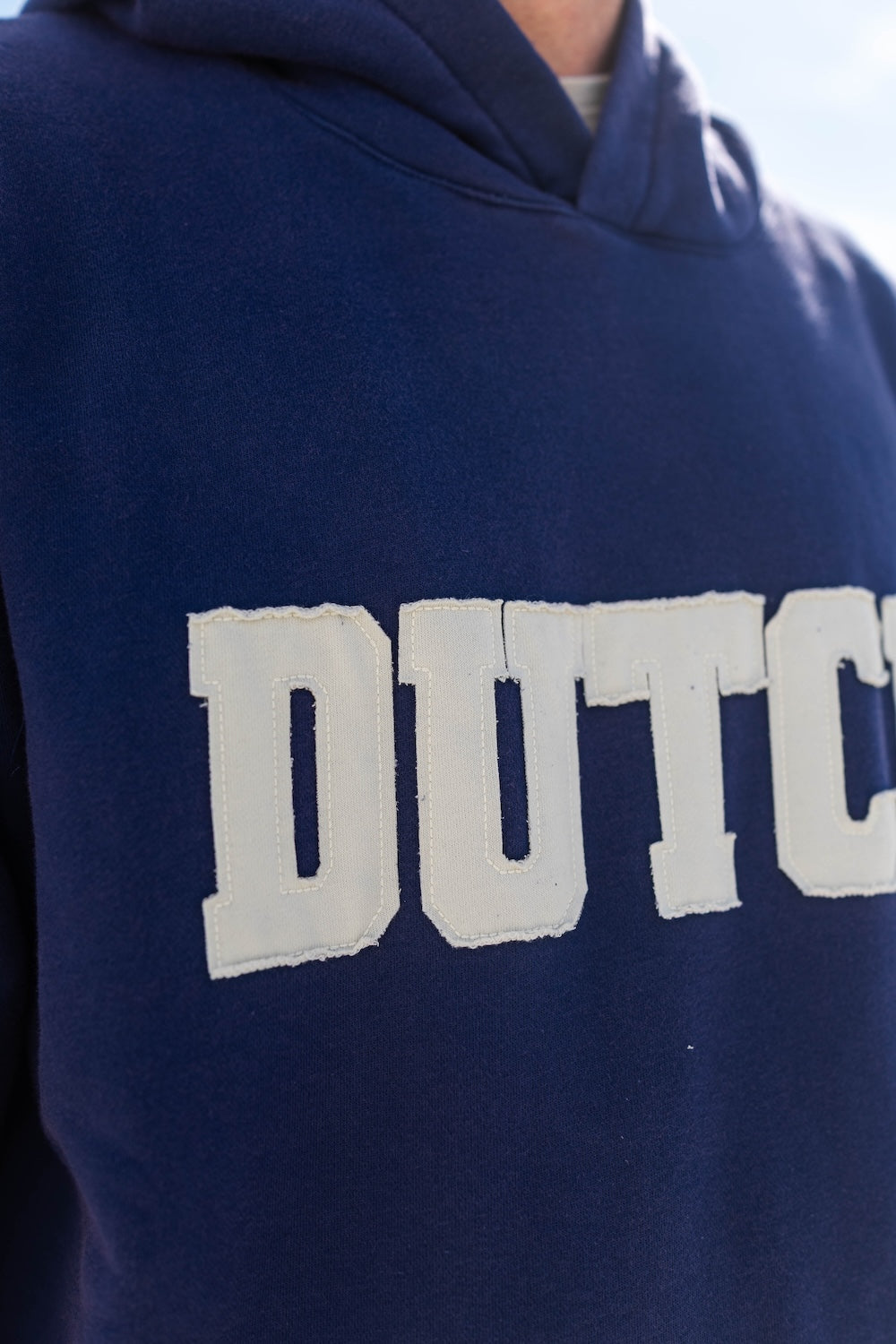 Navy blue hoodie with 'Dutch' printed on the back